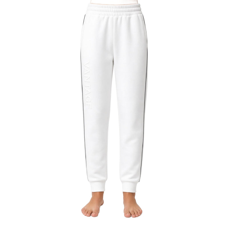 White sweatpants with a subtle tonal vertical logo on the left leg and thin dark side stripes, shown on a model from the waist down against a white background.